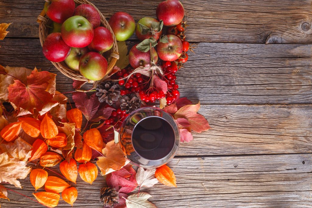 Fall wine with harvest on rustic wooden background